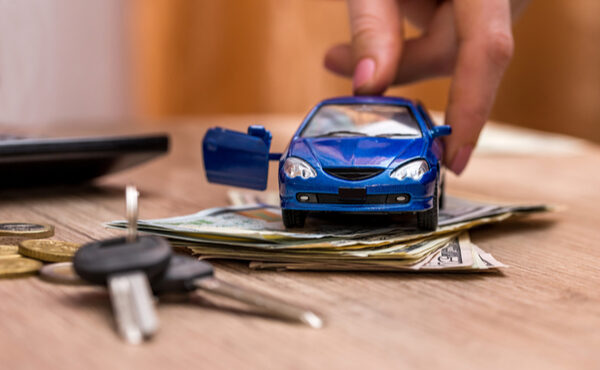 車の模型とお金と鍵が机に置かれている